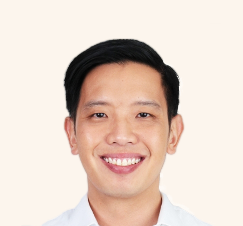Close-up of Minister of State Alvin Tan in a white shirt, smiling in front of light background.